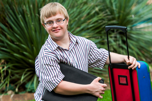 Disabled young man with suit case.